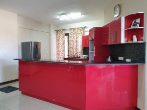 a kitchen with red cabinets and a red counter top at Heaven Heights - Fully Furnished Air Con Apartment in Rose Hill +2 photos