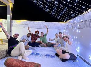 een groep mensen die op een deken in een kamer zitten bij House of Backpackers in Jaipur