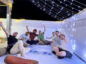 a group of people sitting on a blanket in a room at House of Backpackers in Jaipur