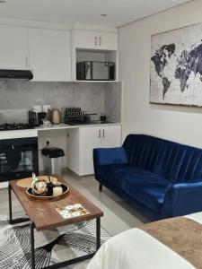 Glorystar The Millennial Umhlanga في ديربان: غرفة معيشة مع أريكة زرقاء وطاولة