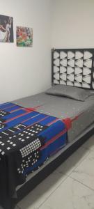 a bed in a room next to a wall at Apartamento de 2 habitaciones en Robledo a 20 minutos del centro in Medellín