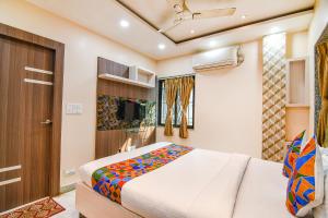 1 dormitorio con 1 cama y TV en FabExpress Scholer Motel, en Calcuta