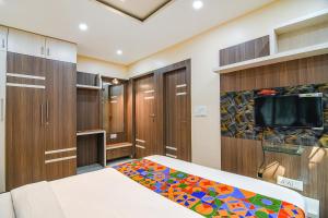 um quarto com uma cama e uma televisão de ecrã plano em FabExpress Scholer Motel em Calcutá