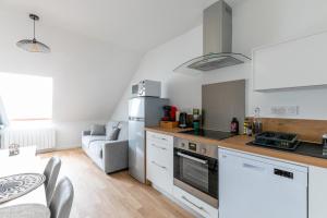 uma cozinha com fogão forno ao lado de um sofá em bel appartement refait a neuf em Vannes
