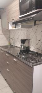 a kitchen with a stove top with a microwave at Apartamento de 2 habitaciones en Robledo a 20 minutos del centro in Medellín