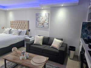 sala de estar con cama y sofá en Glorystar The Millennial Umhlanga en Durban