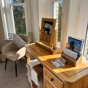 a desk with a mirror and a chair in a room at The Devonian in Ilfracombe