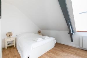 瓦訥的住宿－bel appartement refait a neuf，窗户客房内的一张白色床