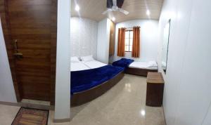 Un dormitorio con 2 camas y una puerta. en Hotel Shiv Ganga, en Varanasi