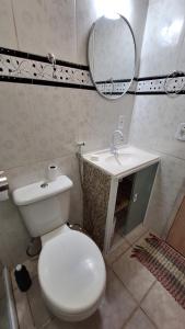 um banheiro com um vaso sanitário branco e uma pia em casa suite cabo frio em Cabo Frio