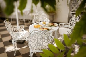 una mesa blanca con platos de comida. en Allegro Hotel, en Liubliana