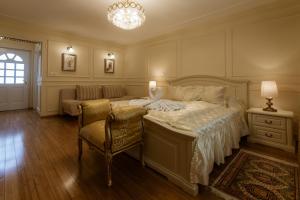 a bedroom with a bed and a couch and a chandelier at Allegro Hotel in Ljubljana