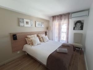 a bedroom with a large bed and a window at La Palmeraie 2 chambres in Sainte-Maxime