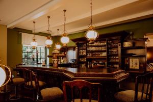 a bar with a counter and chairs in a room at Auehof Hotel & Restaurant in Garrel