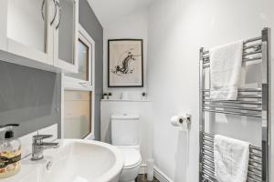 Baño blanco con lavabo y aseo en Deluxe Central Bath House - Sleeps 7, en Bath