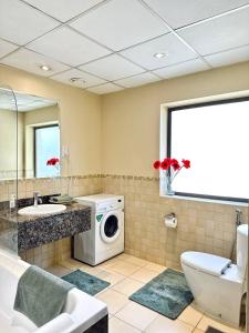 a bathroom with a washing machine and a sink at Sunkissed holiday homes Stunning marina view 4BR plus maid room on JBR beach near mall in Dubai