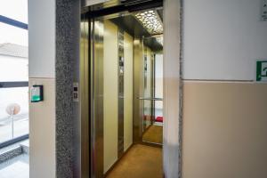 罗镇Bnbook Expo Residence Rho的玻璃门楼内的电梯走廊