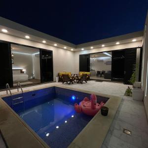 Una piscina en una casa con un flotador rojo. en شاليهات سيليا الفندقية, en Al Mubarraz