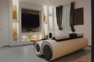 a living room with a couch and a tv at Wood 47 spa in Précy-sur-Oise