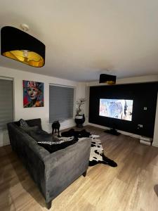 a living room with a couch and a flat screen tv at Modern and spacious two bedroom apartment near city centre in Bristol