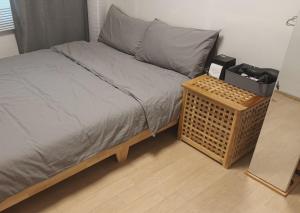 a bed with a wooden bed frame next to a table at Haeundae Mipo House1 블루라인파크와LCT워터파크앞 바다도보2분 in Busan