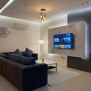 un soggiorno con divano e TV a schermo piatto di شاليهات سيليا الفندقية a Al Mubarraz