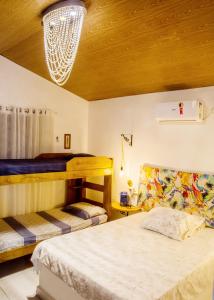 a bedroom with two beds and a chandelier at Paradise Camp in Monte das Gameleiras