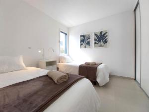 a white bedroom with two beds and a window at Royal Blue Corralejo by Sea You There Fuerteventura in Corralejo +33 photos