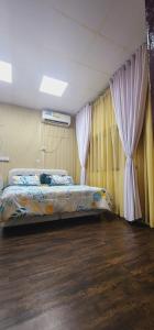 a bedroom with a bed with curtains and a wooden floor at Modern Comfort - AlGhurair Mall in Dubai