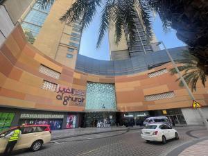 a large building with cars parked in front of it at Modern Comfort - AlGhurair Mall in Dubai