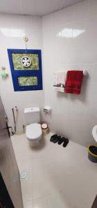 a white bathroom with a toilet and a sink at Modern Comfort - AlGhurair Mall in Dubai