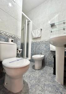 a white bathroom with a toilet and a sink at VibesCoruña - Bergondo 10 in A Coruña