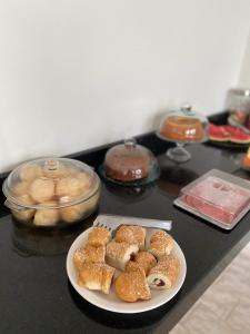 a plate of pastries on a counter next to a table at Hotel E Flats LISBOA in Presidente Médici
