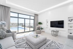 - un salon avec un canapé et une télévision dans l'établissement Nasma Luxury Stays - Luxurious Villa with Private Pool & Beach Access, à Fujaïrah