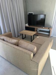 ein Wohnzimmer mit einem Sofa und einem Flachbild-TV in der Unterkunft Casa Valentino in Rafaela