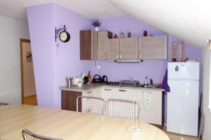 a kitchen with purple walls and a table and a refrigerator at Jazdecký areál Budička in Trnie