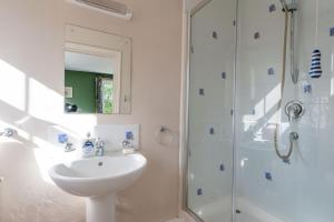 a white bathroom with a sink and a shower at FIRS Sleeps 15 Stunning country house with hot tub in Sudbourne