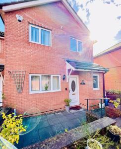 a red brick house with a white door at Tanglewood Close, 3 Bedroom house, Abergavenny with private parking, in Abergavenny