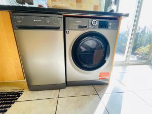 a washing machine is sitting in a room at Tanglewood Close, 3 Bedroom house, Abergavenny with private parking, in Abergavenny