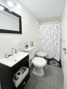 a white bathroom with a toilet and a sink at EL ENCANTO DEL CENTRO CORAZÓN DE SANTA FE ARGENTINA in Santa Fe