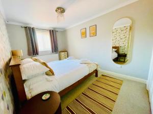 Dormitorio pequeño con cama y espejo en Tanglewood Close, 3 Bedroom house, Abergavenny with private parking,, en Abergavenny