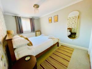 a small bedroom with a bed and a mirror at Tanglewood Close, 3 Bedroom house, Abergavenny with private parking, in Abergavenny