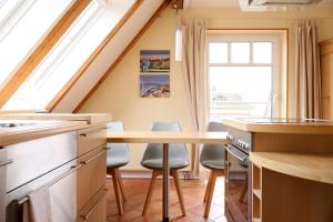 a kitchen with a table and chairs and a window at Foerdeloge in Laboe