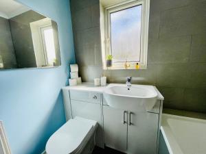 y baño con lavabo, aseo y espejo. en Tanglewood Close, 3 Bedroom house, Abergavenny with private parking,, en Abergavenny