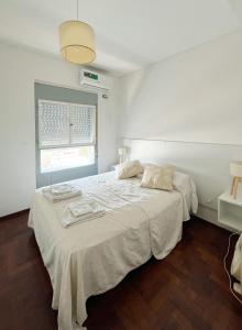 1 dormitorio con 1 cama blanca grande y ventana en EL ENCANTO DEL CENTRO CORAZÓN DE SANTA FE ARGENTINA en Santa Fe