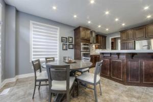 a kitchen with a dining room table and chairs at Elegance: Luxurious Stay in the Heart of Community in Brampton