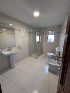a bathroom with two sinks and a shower and a toilet at Piso para familias numerosas in Garray