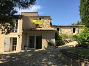 una casa con un paraguas amarillo en la parte delantera en LA BASTIDE FERREOL, en La Motte-dʼAigues