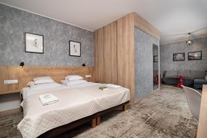 um quarto com uma cama grande e uma sala de estar em Hotel Biancas em Kosakowo