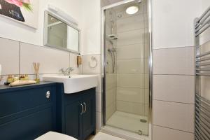 La salle de bains est pourvue d'un lavabo et d'une douche. dans l'établissement Grange Bank House, à Shanklin